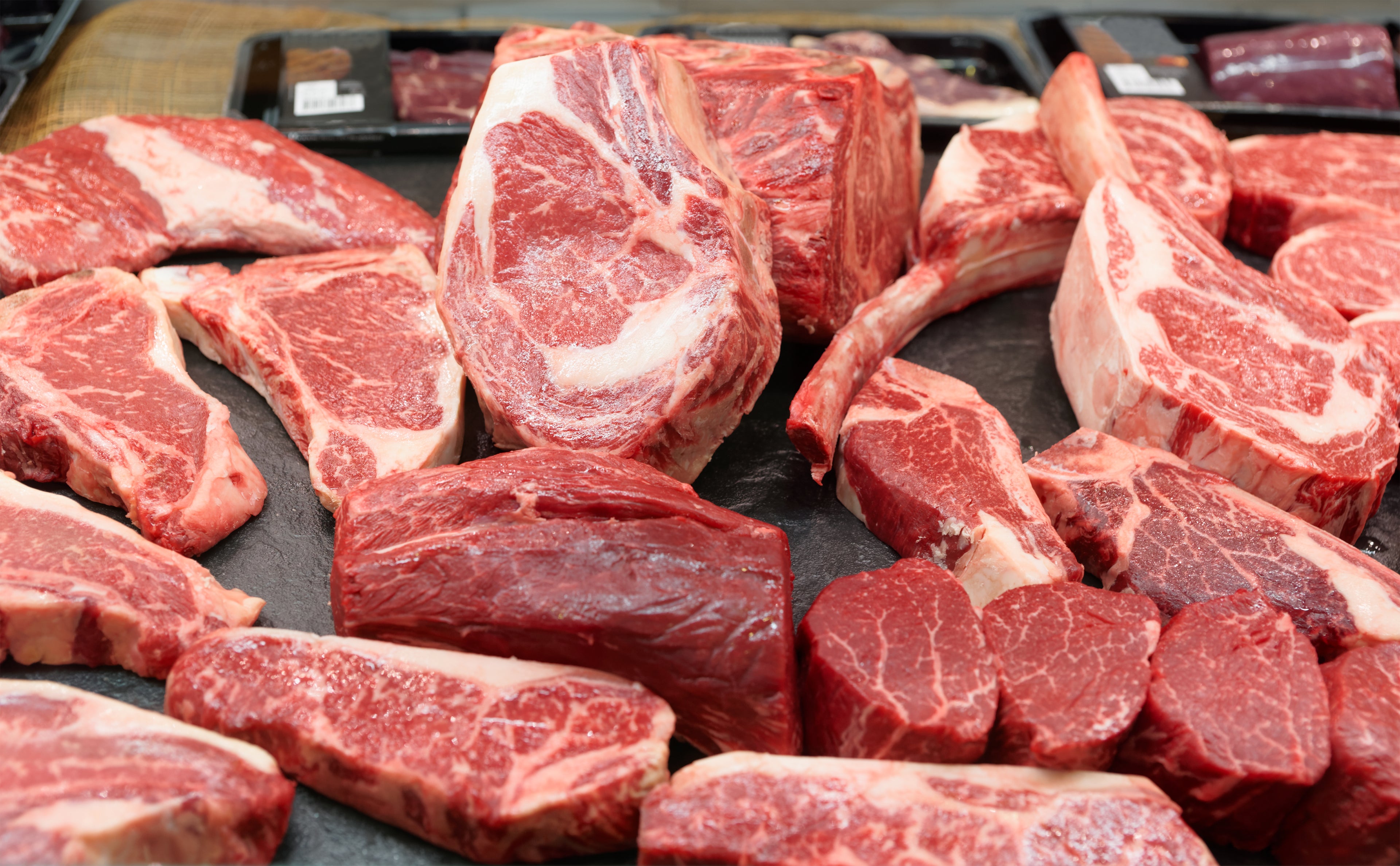 raw cuts of meat on a dark background Frontier Meat Packing