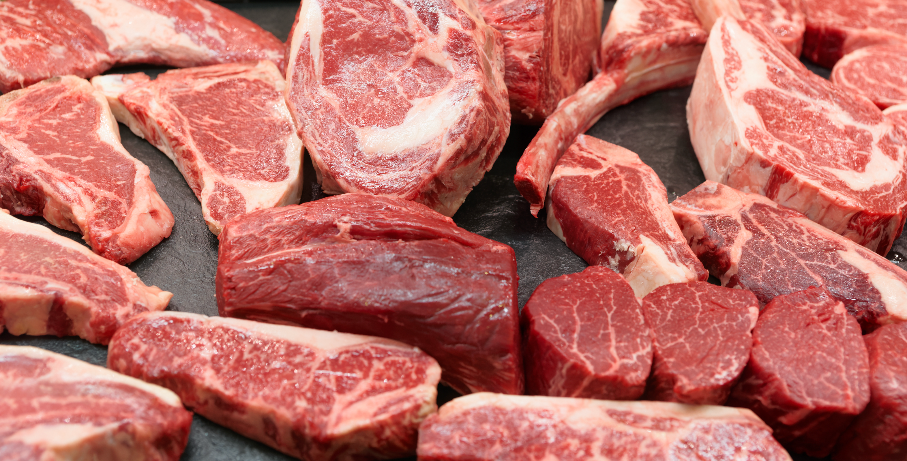 raw cuts of meat on a dark background Frontier Meat Packing
